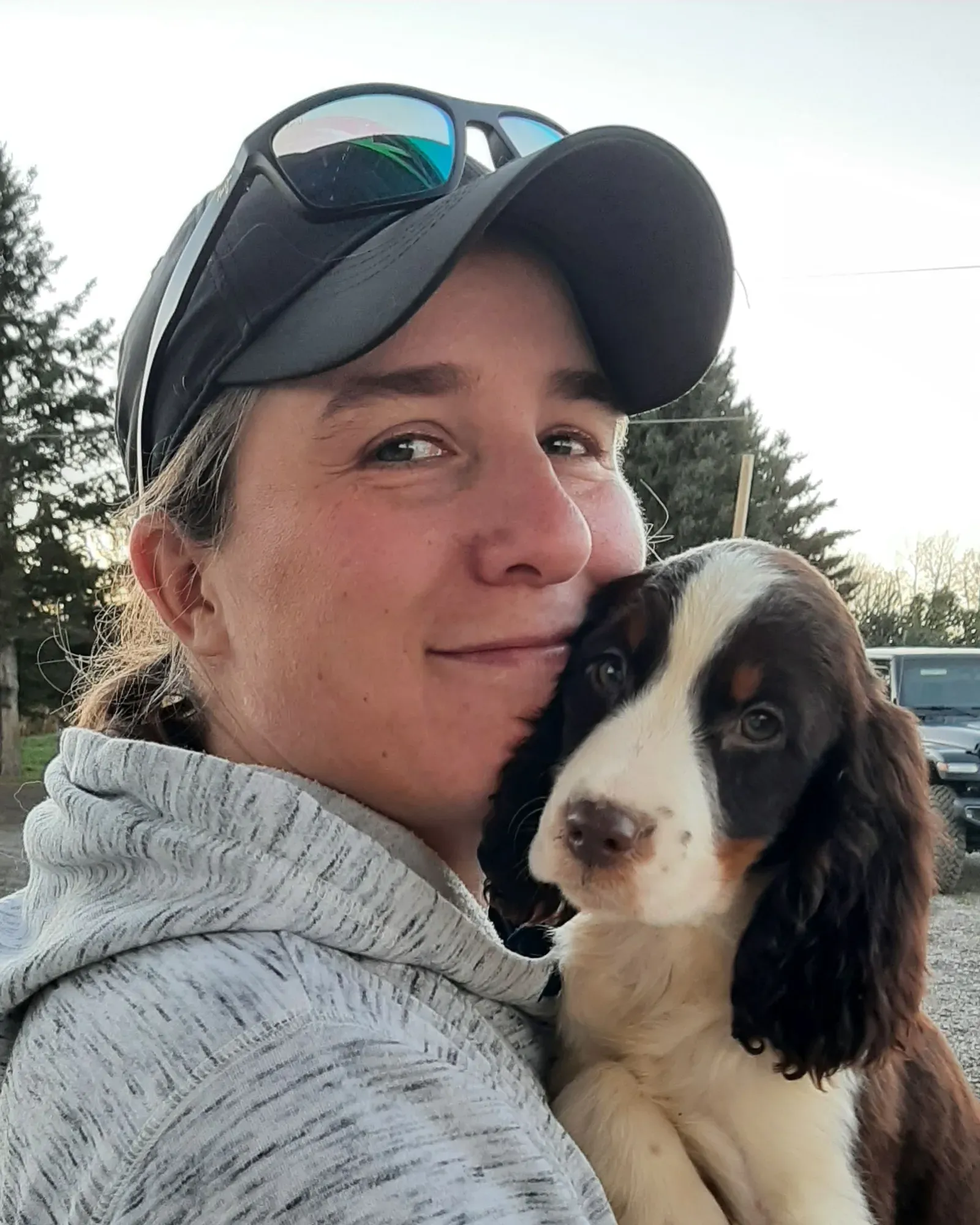 Jamie Scrimger holding a springer spaniel puppy, both looking towards the camera.